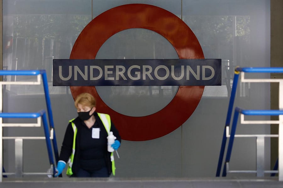 A woman, wearing PPE (personal protective equipment) as a precautionary measure against COVID-19, cleans the railings at a tube station in London. Credit: AFP Photo