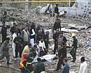 Pakistani rescue workers carry a blast victim at the site of a blast in Faisalabad, Pakistan on Tuesday. A car bomb outside a gas station killed many people and wounded more than 100. AP Photo