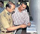 Commissioner of Police B G Jyothi Prakash Mirji and Joint Commissioner (Crime) Alok Kumar look at the siezed articles in Bangalore on Sunday. DH Photo
