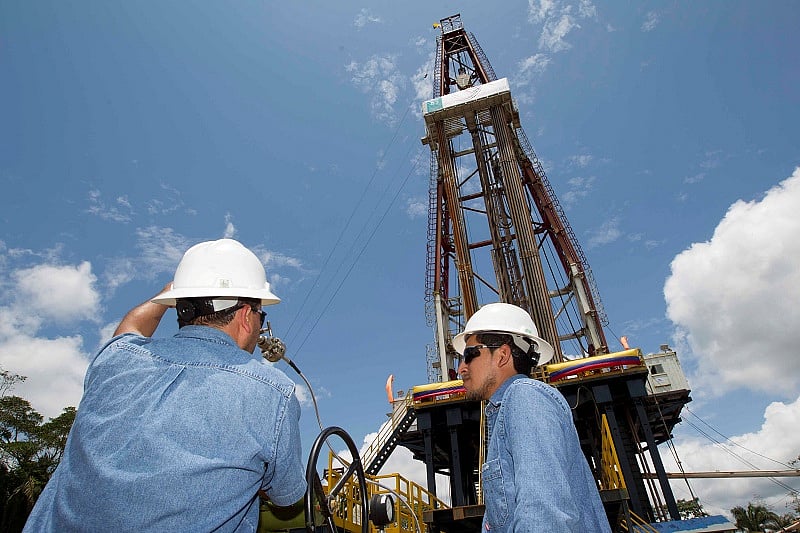 Workers stand near an oil drilling rig belonging to Petroamazonas at Miranda Port in Tiputini, Ecuador. (Reuters Photo)