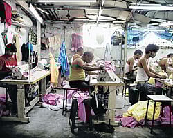 Abysmal conditions: Workers sew clothes in a garment factory owned by Mohammad Mustaqueem, in Dharavi slum, Mumbai. More than a warehouse for the poor, Dharavi contains a hive of workshops with an annual economic output of more than Rs 3000 crore. NYT