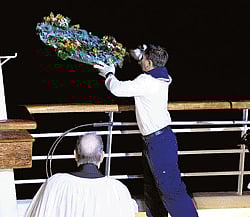 A crew member throws a wreath during a memorial service, marking the 100th year anniversary of the Titanic disaster, aboard the MS Balmoral Titanic memorial cruise ship, at the wreck site in the North Atlantic Ocean, on Sunday. AP
