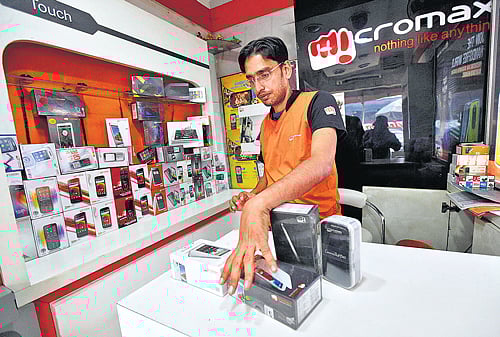 A worker displays a Micromax mobile phone inside a store in Kolkata. The company has become India's No 2 smartphone brand in five years. Reuters