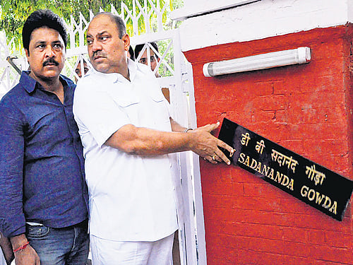 Congress ex-MLA Mukesh Sharma removes the name-plate of Railway Minister DV Sadananda Gowda during a protest demanding rollback of rail fare hike outside Railway Minister's house, in New Delhi on Tuesday. DH Photo