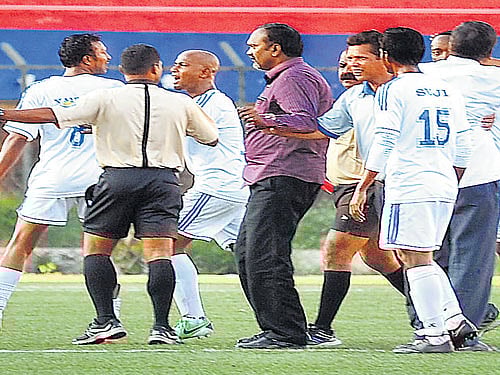 not done: A Students Union supporter targets referee Elangovan, upset over his decision to send off Xavier Vijay Kumar. RIGHT:&#8200;Xavier (left) leaves the  field after he received his second yellow card from the referee. DH&#8200;photos/ Srikanta Sharma R