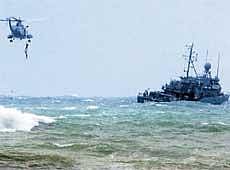 Search for life: A Lebanese commando pulls a body from the water into a helicopter above the area where an Ethiopian plane crashed as a vessel (R) searches for survivors at Khaldeh, south of Beirut, on Monday. Reuters