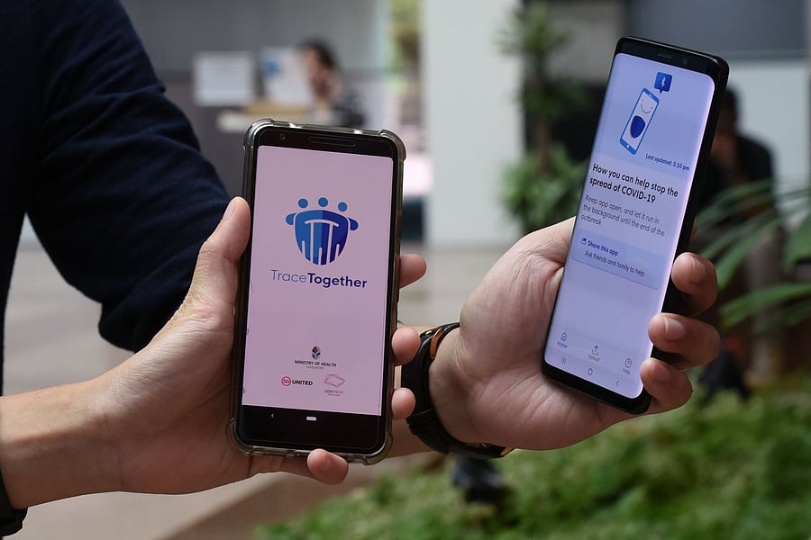 Government Technology Agency (GovTech) staff demonstrate Singapore's new contact-tracing smarthphone app, as a preventive measure against the COVID-19 coronavirus in Singapore on March 20, 2020. (Credit: AFP Photo)