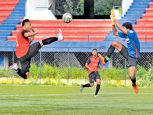 Acrobatic: ASC's Jotin Singh (left) tries to score past RWF's goalkeeper Arun during their Super Division tie at the Bangalore Football stadium in Bengaluru on Thursday. dh photo