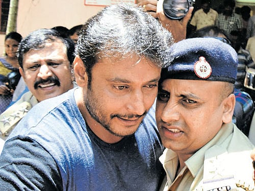 Kannada film actor Darshan with a police inspector as he comes out of the Thyagarajanagar police station after an  enquiry on Saturday. DH&#8200;photo