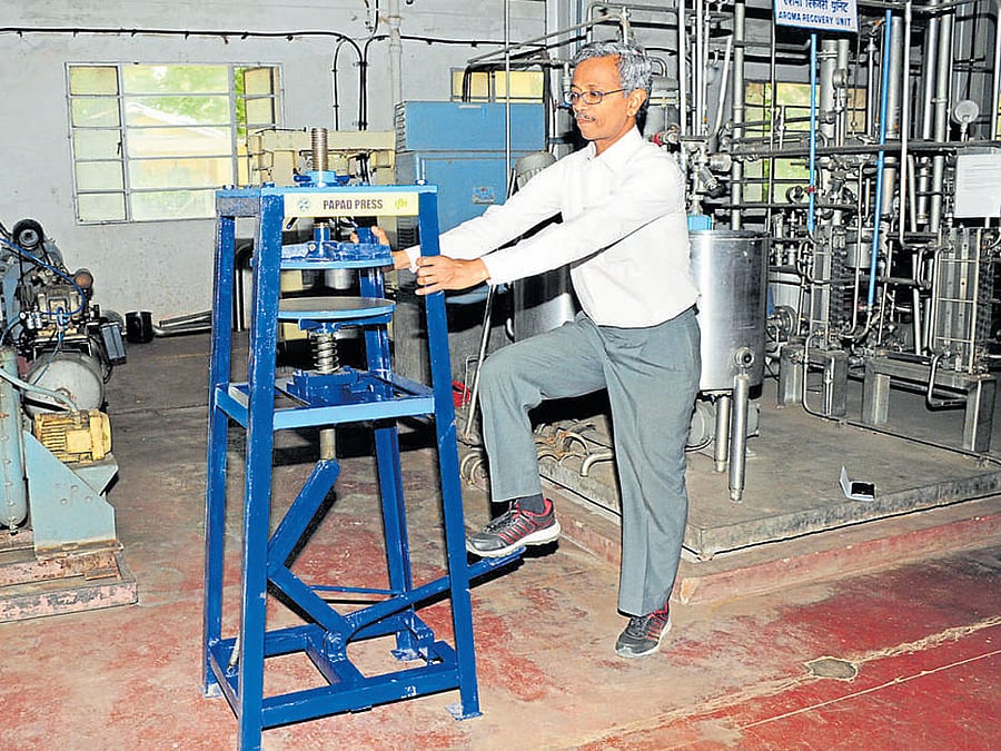 A Central Food Technological Research Institute official demonstrates the functioning of 'Leg Operated Papad Press' on CFTRI premises in Mysuru on Thursday. DH photo