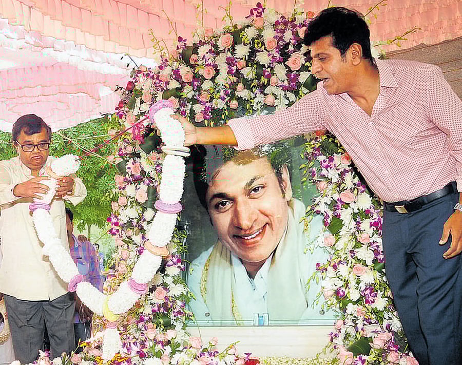 Actors Shivrajkumar and Dwarakeesh garland the samadhi of Rajkumar on his 89th birth anniversary at the Kanteerava Studios on Monday. dh photo