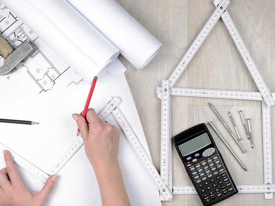 Hands of engineer working with the tool on project drawings background