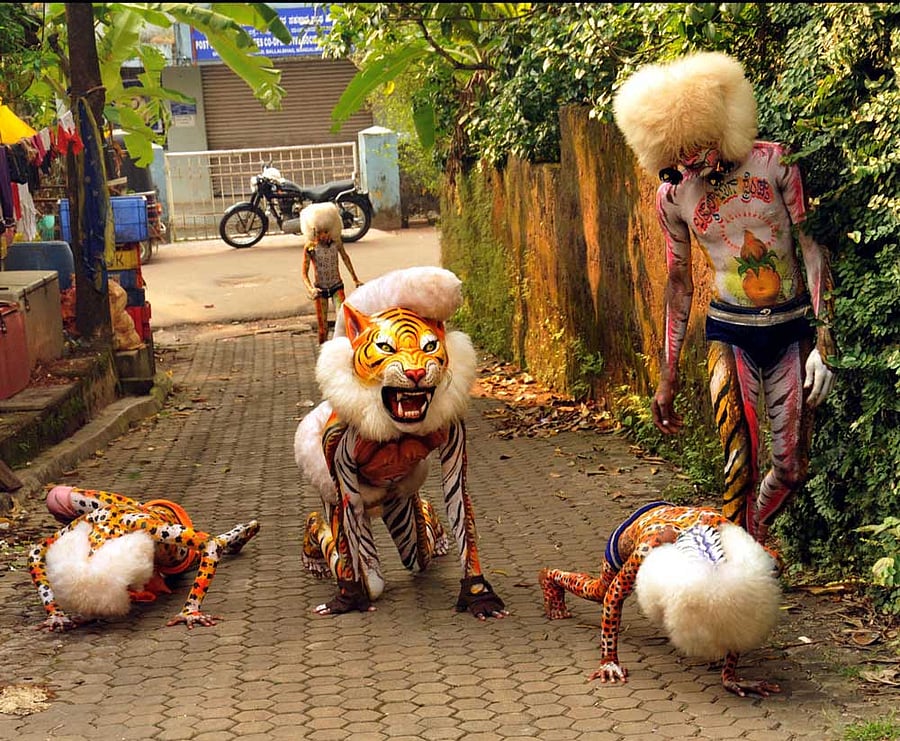 Scintillating: Members of 'hulivesha' troupes perform many acts such as fire breathing, handstands and gymnastic moves. DH Photo by Govindraj Javali