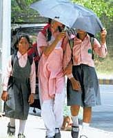 Sun shield: School girls protect themselves from the scorching heat as the mercury rises above normal in New Delhi on Monday. PTI