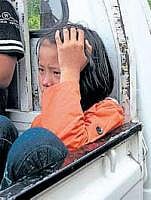 A girl reacts as she sits in the back of a pick-up truck at the site of an explosion in Yangon on Thursday. AFP