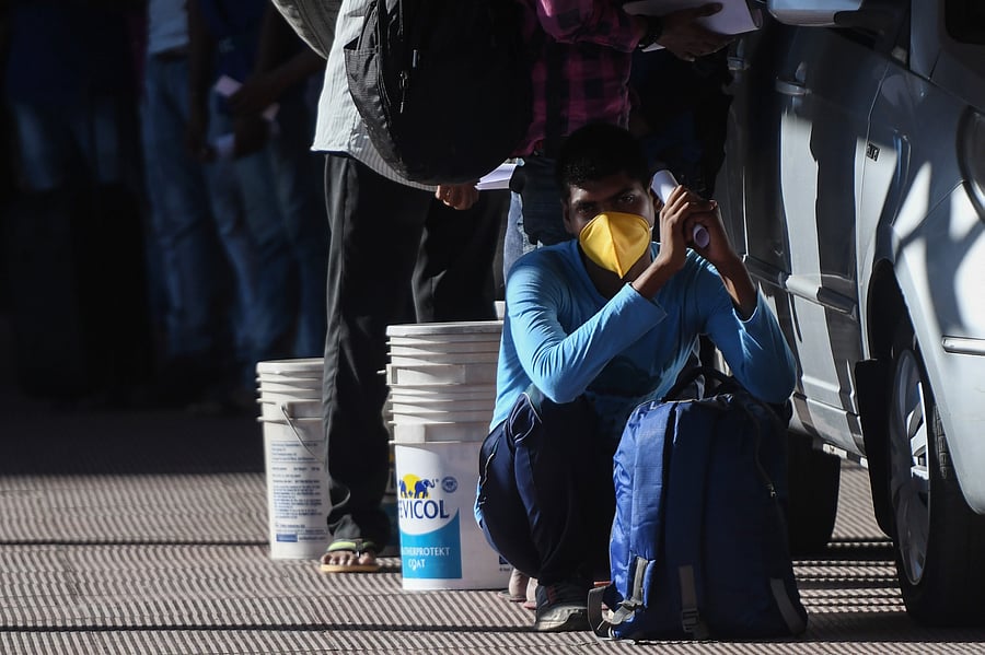 Stranded migrant workers wait with their belongings to board a special train to Bihar from MGR Central railway station after the government eased a nationwide lockdown imposed as a preventive measure against the COVID-19 coronavirus. (AFP Photo)