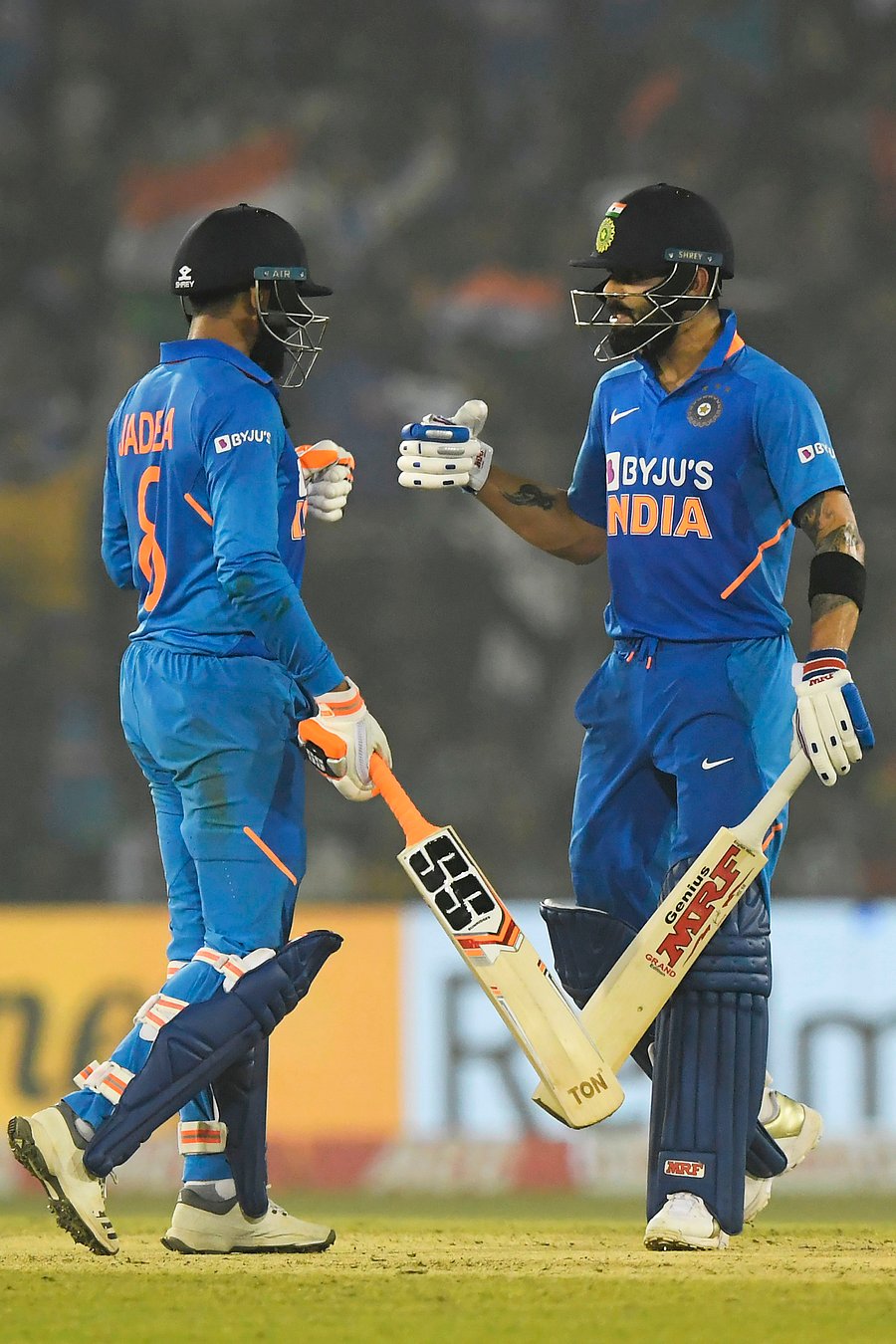 India's Ravindra Jadeja (L) clebrates after scoring a boundary with captain Virat Kohli during the third one day international cricket match of a three-match series between India and West Indies at the Barabati Stadium in Cuttack. (AFP Photo)