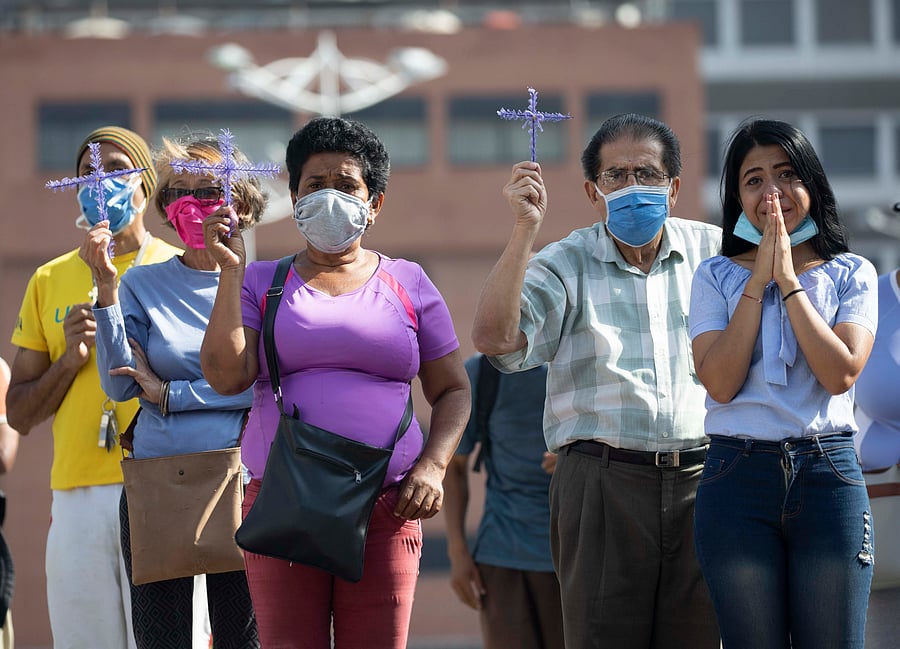 Devotees of the "Nazareno de San Pablo" watch a statue of Jesus pass by in a Pope mobile during Holy Week celebrations in Caracas, Venezuela. (AP Photo)