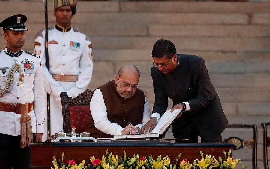 Amit Shah signs documents after taking his oath as a cabinet minister during a swearing-in ceremony at the presidential palace in New Delhi, India May 30, 2019. Reuters fIle photo