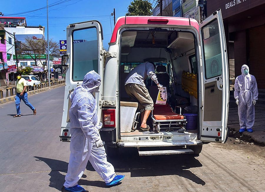 Medical workers escort a suspected coronavirus patient to get in an ambulance as he is shifted to a hospital for treatment (PTI Photo)