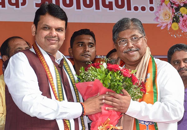 Chief Minister Devendra Fadnavis greets the new BJP State President Chandrakant Patil, during a felicitation event in Mumbai. (PTI photo)