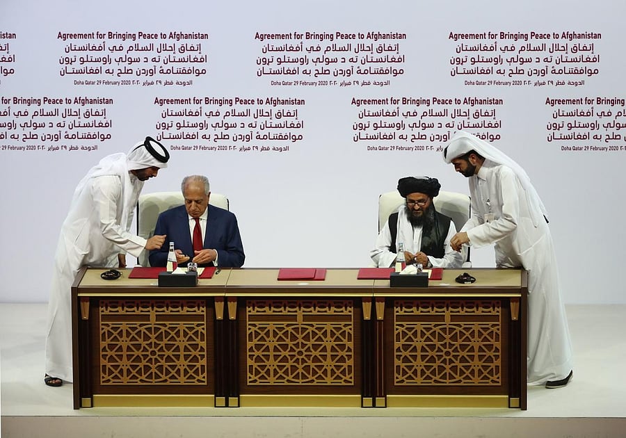 US Special Representative for Afghanistan Reconciliation Zalmay Khalilzad and Taliban co-founder Mullah Abdul Ghani Baradar sign a peace agreement during a ceremony in the Qatari capital Doha on February 29, 2020. Credit: AFP Photo