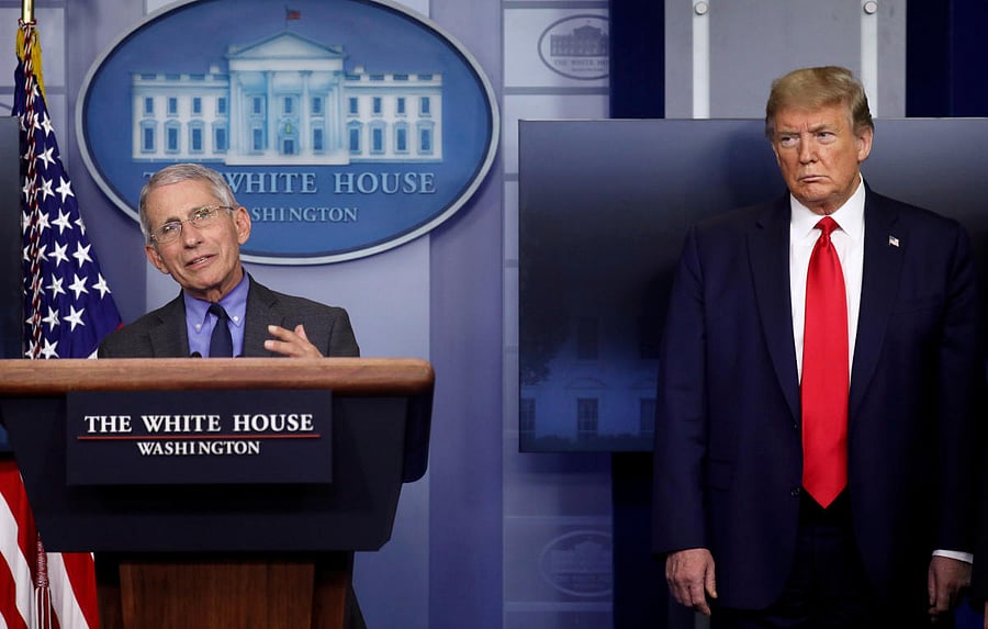 US President Trump listens to Dr. Anthony Fauci during the daily coronavirus response briefing at the White House in Washington. Credit: Reuters Photo