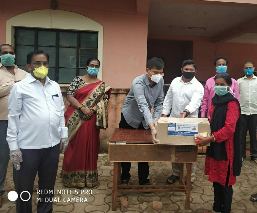 Medium and Large Scale Industries Minister Jagadish Shettar’s son, Sankalp Shettar, distributing Infosys Foundation's kit in Hubballi on Friday. (Credit: DH Photo)