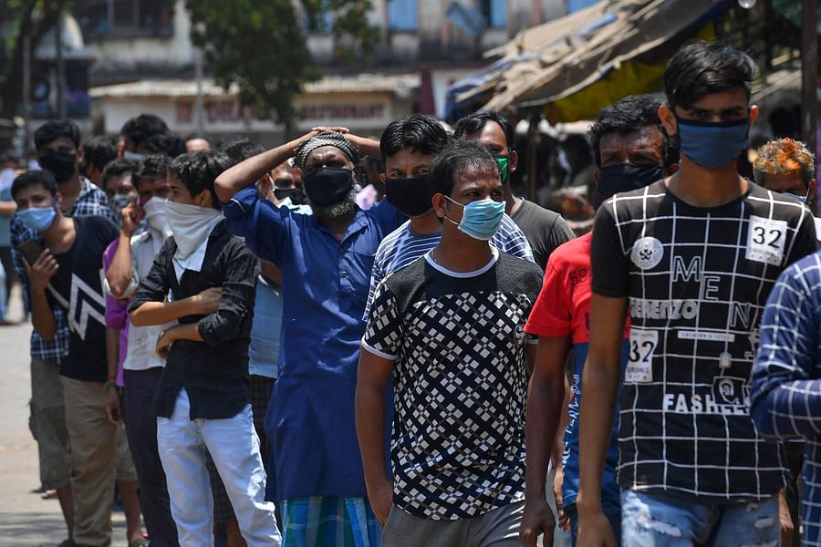 Stranded migrant workers stand in a queue while they wait to register for special transportations organized to bring them back to their hometowns during a government-imposed nationwide lockdown as a preventive measure against the spread of the COVID-19 coronavirus, in Mumbai on May 2, 2020. Credit: AFP Photo
