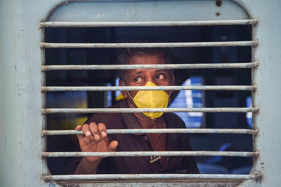  A migrant looks through a window during his departure by 'Shramik Special' train (PTI Photo)
