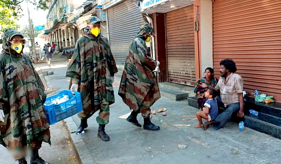 Bengaluru: Army personnel distribute food packets among poor people during a nationwide lockdown in the wake of coronavirus pandemic. (Credit: PTI)