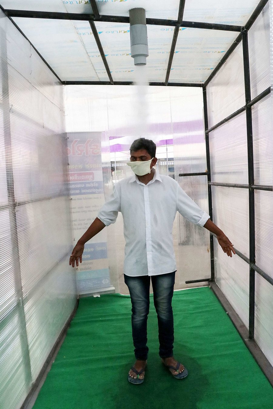 A medical worker shows how the sanitization facility set up inside the Institute for Kidney Diseases & Research Centre (IKDRC) works, in Ahmedabad. (Credit: PTI)