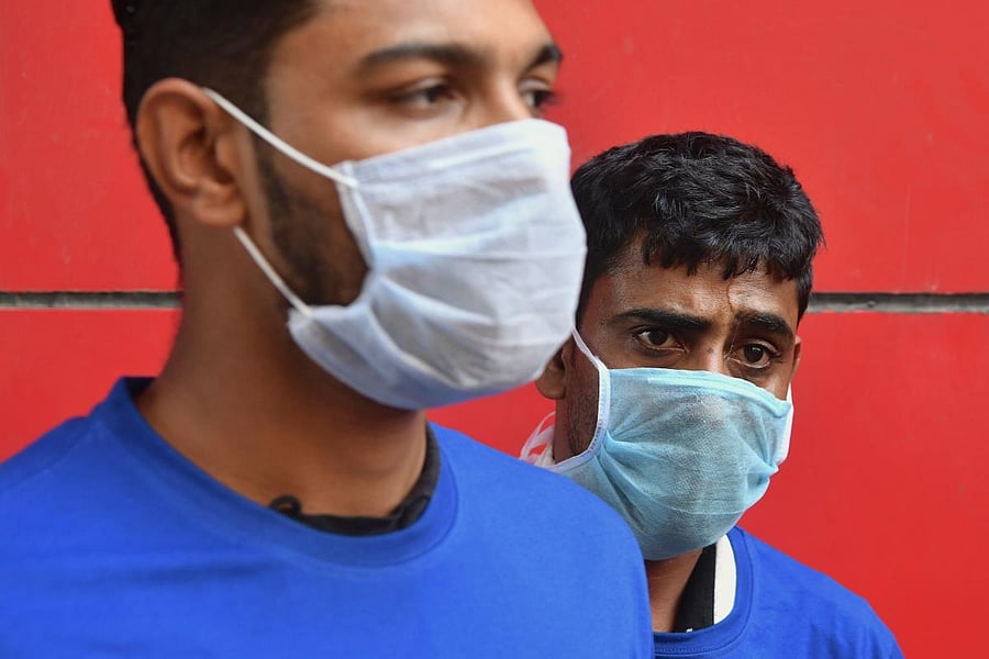 Health volunteers wearing facemasks look on as doctors from a government hospital demonstrate preventive measures to commuters using public transport against the spread of the coronavirus during an awareness campaign in Bengaluru. AFP