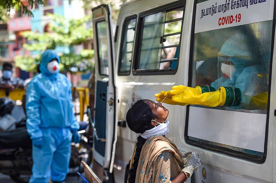 A health worker collects samples for a swab test of a policewoman from a mobile COVID-19 testing van, during the nationwide lockdown to curb the spread of coronavirus, in Chennai, Wednesday, April 22, 2020. (PTI Photo)