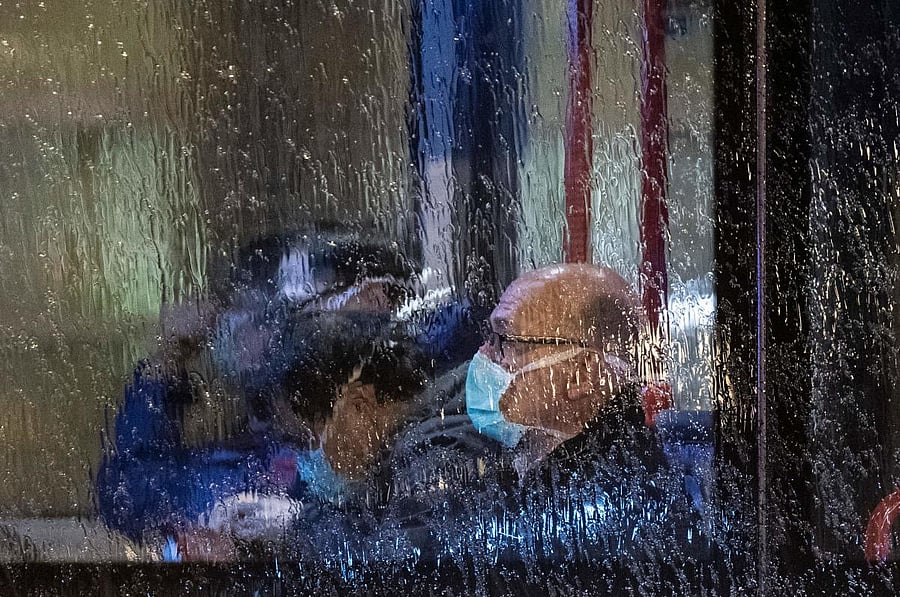 People, wearing masks, are seen through the window of a bus with on board German and foreign nationals evacuated from the Chinese city of Wuhan, the epicentre of the coronavirus outbreak, as the bus leaves Frankfurt am Main's airport to make its way to a military base in Germersheim on February 1, 2020. (AFP Photo)