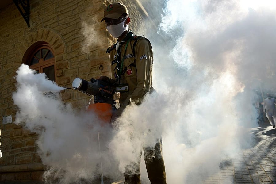 A worker spray disinfectant in Pakistan (AFP Photo)