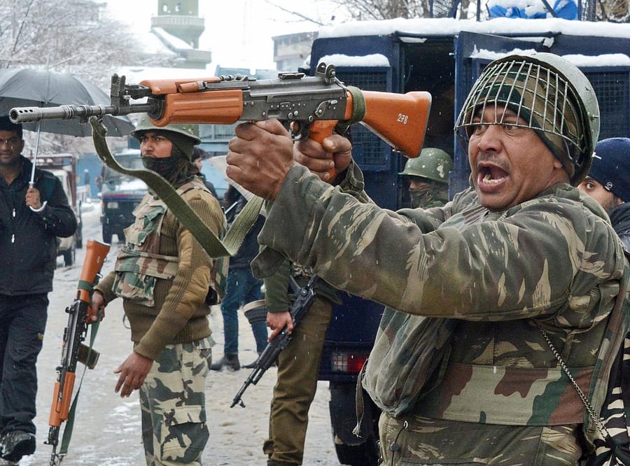 Security personnel take positions during an encounter with the militants who were holed up in a building near a CRPF camp in Srinagar. (PTI file photo)