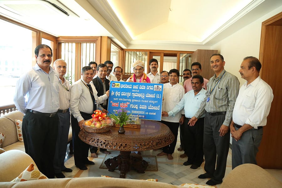 LIC of India Zonal Manager T C Susheel Kumar hands over the master policy of Jeeva Bima Bhadrathe scheme to Dharmasthala Dharmadhi D Veerendra Heggade.