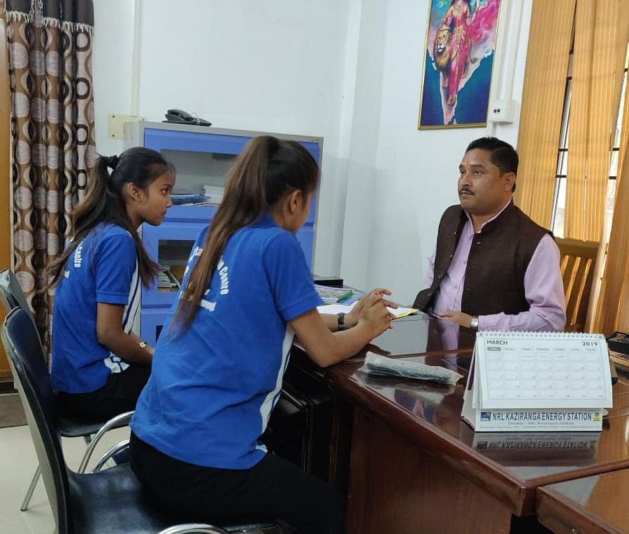 Two adolescent girls handing over a copy of children's agenda to Dilip Saikia, general secretary of Assam unit of BJP, on Monday in Guwahati. Photo by Chiranjeeb Kakoty.