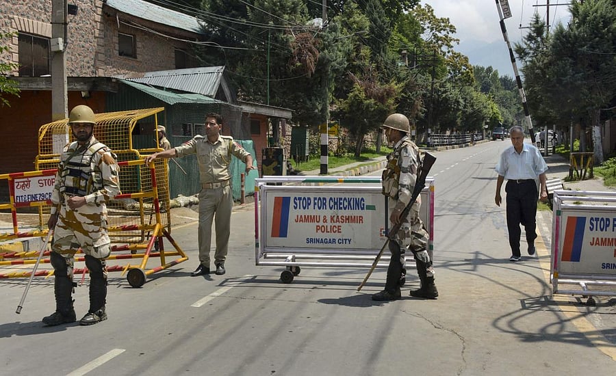 Security personnel stand guard as they block a road leading to the residence of Farooq Abdullah, Omar Abdullah and Mehbooba Mufti during restrictions in Srinagar. (PTI Photo)