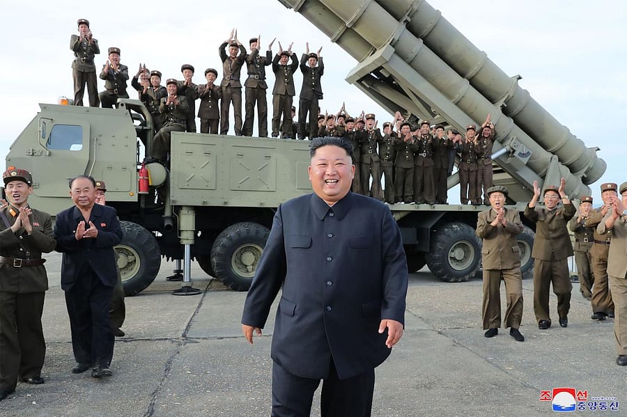 North Korean leader Kim Jong Un (C) celebrating the test-firing of a 'newly developed super-large multiple rocket launcher' at an undisclosed location. Photo/KCNA VIA KNS/AFP