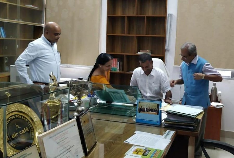 Professor Sudhir Krishnaswamy signs documents, formalising his appointment as the vice-chancellor of the National Law School of India University on Wednesday. To his left is former interim VC Professor M K Ramesh and to right is the registrar, professor N