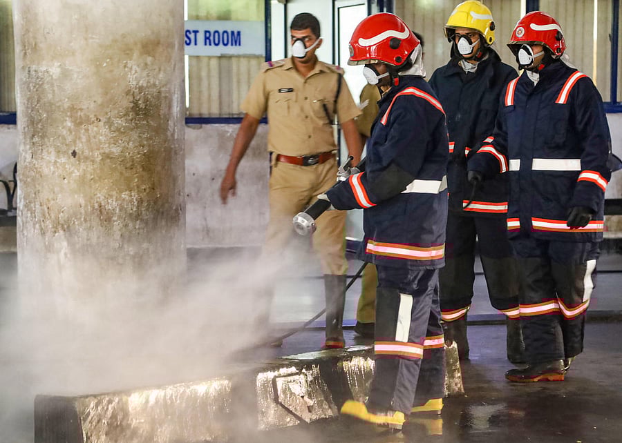 Workers spray disinfectant in the premises of KSRTC bus stand to contain the spread of coronavirus, in Kozhikode. PTI