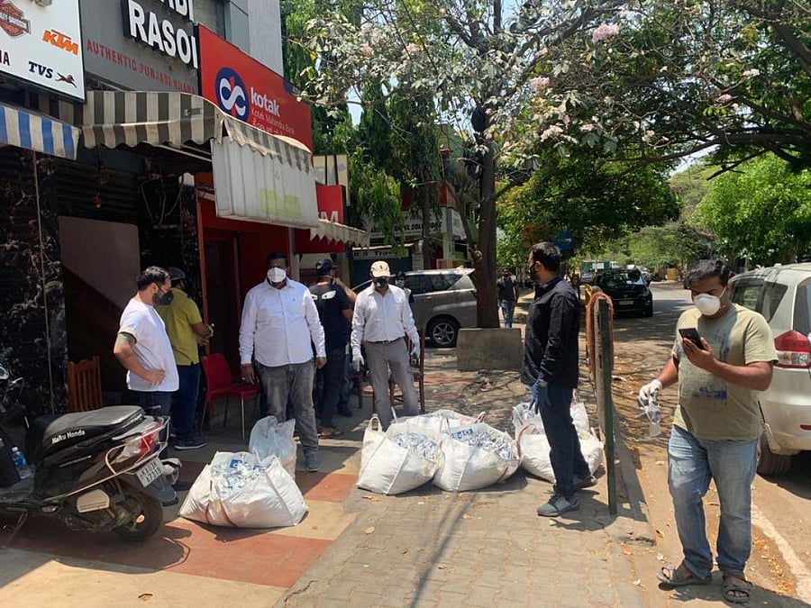 Volunteers distribute food packets near Old Madras Road in Bengaluru. DH Photo