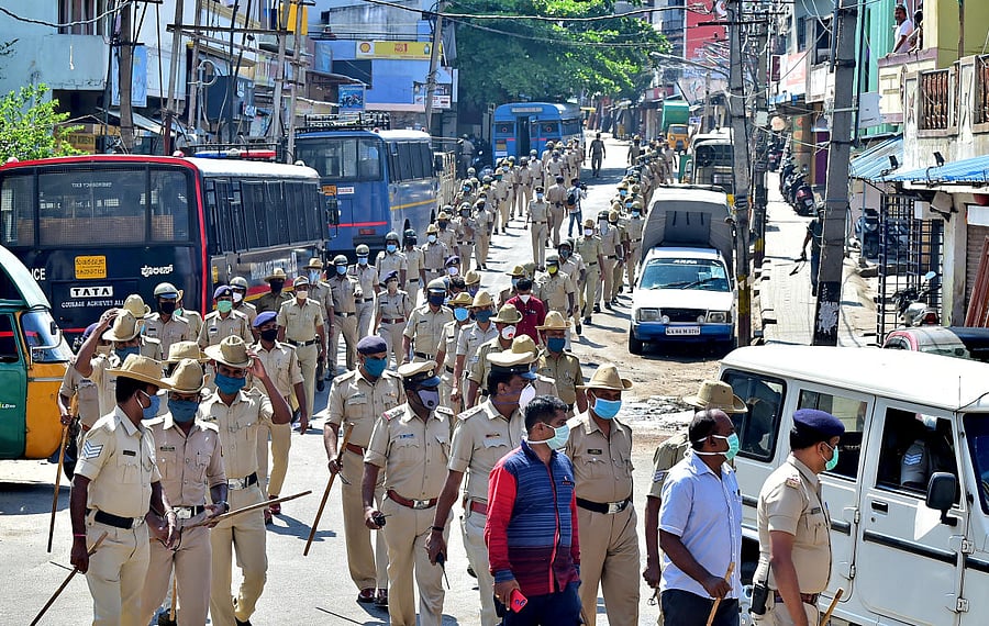 Policemen march on the streets of Padarayanapura following Sunday night's vandalism. DH PHOTO/RANJU P