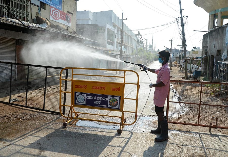 A personnel of the Fire and Emergency Services spray disinfectant in Davangere on Friday. DH Photo