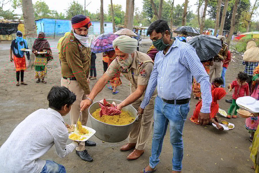 Punjab police personnel distribute food to needy people during the nationwide lockdown, in wake of coronavirus outbreak (PTI Photo)