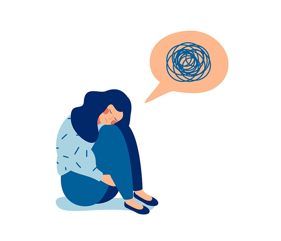 Woman in depression with bewildered thoughts in her mind. Young sad girl sitting and unhappy hugging her knees. (Credit: iStockPhoto)
