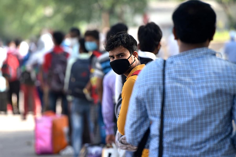 Migrant workers and their family members queue to enter inside a railway station to board on the Shramik Express directed to the Indian state of Bihar, during a government imposed nationwide lockdown as a preventive measure against the COVID-19 coronavirus, in Faridabad on May 15, 2020. Credit: AFP Photo