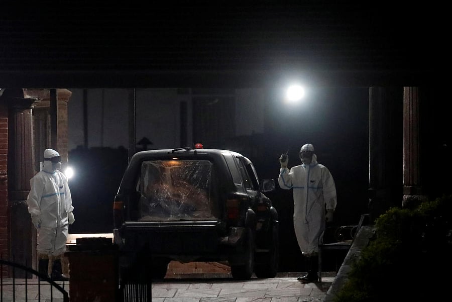 Officials in protective gears stand near a vehicle carrying the body of a 29-year-old woman who gave birth to a child on May 6, and died due to the coronavirus disease (COVID-19), marking the first case of fatality as the country is under lockdown for the fifty-fourth day, in Kathmandu, Nepal, May 16, 2020. Credit: Reuters Photo